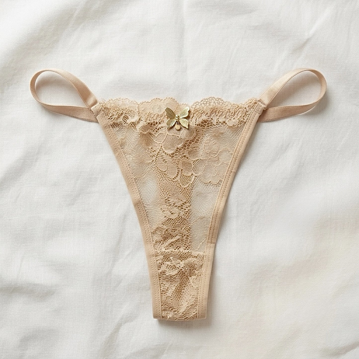 Tanga de encaje floral color arena con detalle de mariposa dorada — Aurora Femme